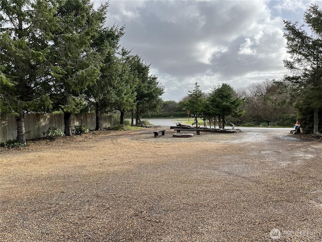 view of yard with a water view and fence