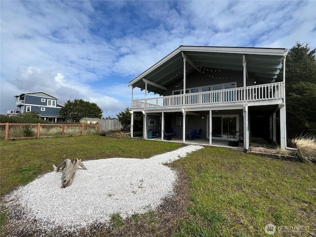 back of property with fence, a lawn, and a patio