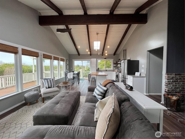 living area featuring high vaulted ceiling, dark wood-style flooring, and beamed ceiling