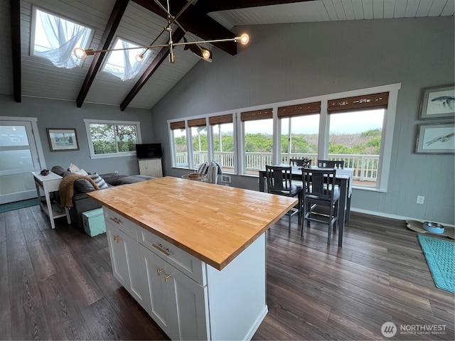 kitchen with a skylight, white cabinets, dark wood finished floors, and wood counters