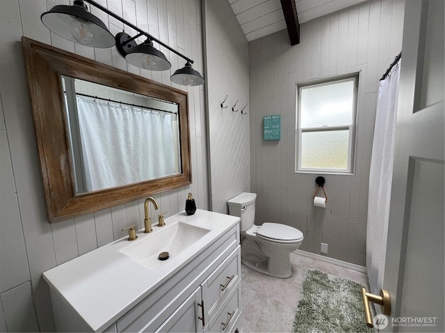 full bathroom with toilet, beam ceiling, and vanity