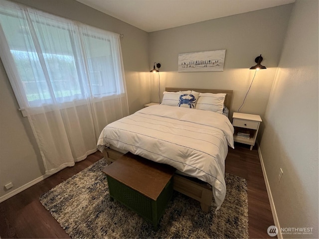 bedroom with dark wood-type flooring and baseboards