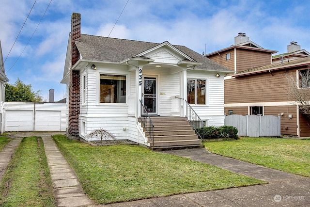 bungalow with an outbuilding, a front yard, and a garage