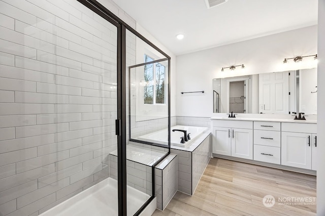 bathroom with vanity, plus walk in shower, and hardwood / wood-style floors