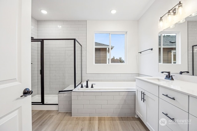 bathroom featuring hardwood / wood-style flooring, vanity, and plus walk in shower