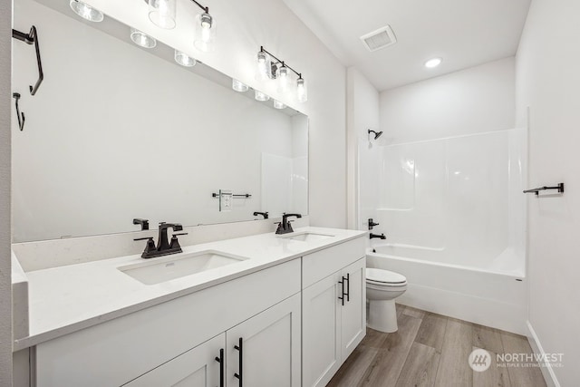 full bathroom featuring toilet, vanity, shower / tub combination, and hardwood / wood-style floors