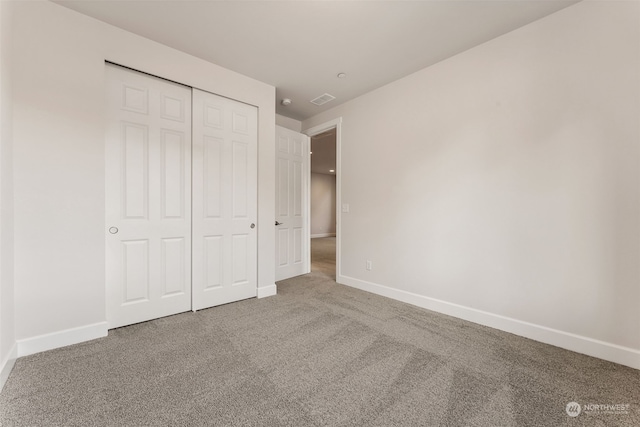 unfurnished bedroom featuring a closet and carpet flooring