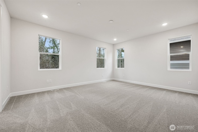 empty room with carpet floors and plenty of natural light