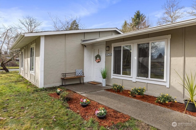 entrance to property featuring a lawn