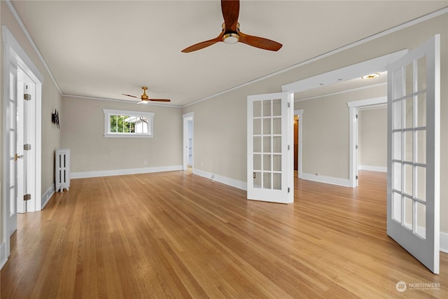 unfurnished living room featuring radiator heating unit, ornamental molding, french doors, and light wood-type flooring