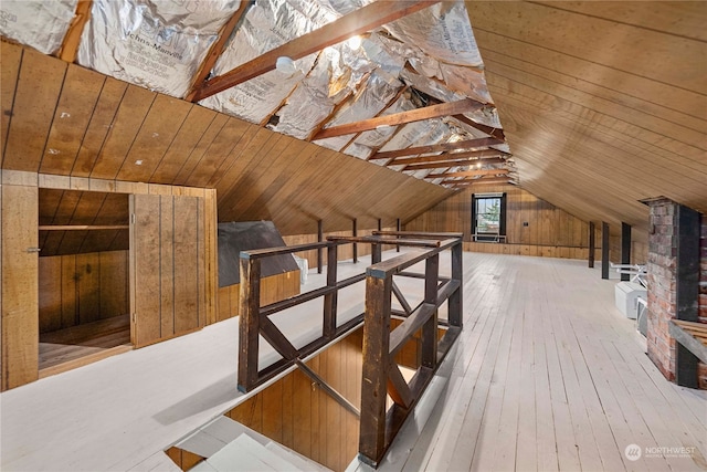 additional living space with wood walls, wooden ceiling, hardwood / wood-style floors, and lofted ceiling