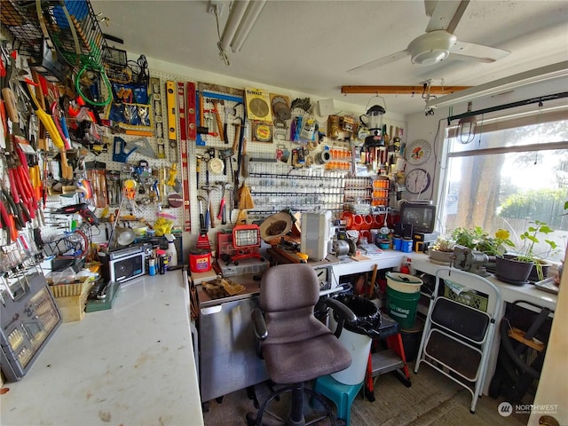 misc room with a workshop area, ceiling fan, and concrete flooring