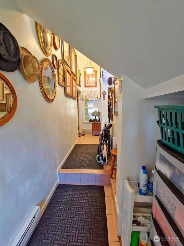 corridor with a baseboard radiator and dark tile patterned flooring