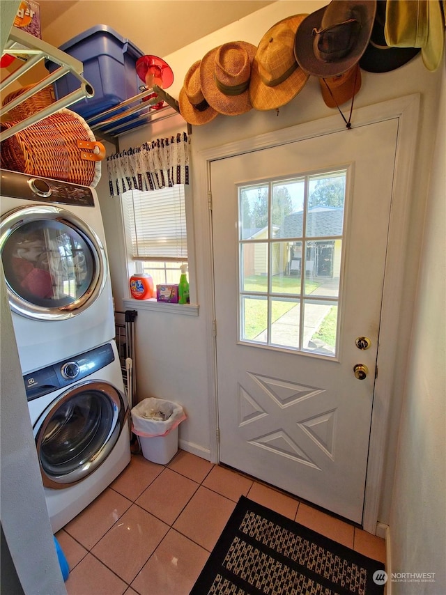 laundry area featuring stacked washer and dryer and light tile patterned flooring