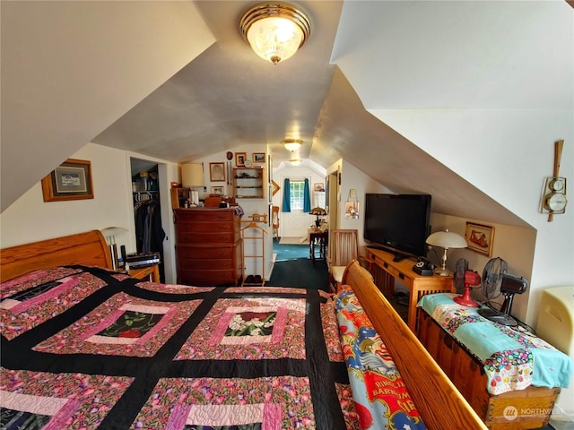 bedroom with a walk in closet, lofted ceiling, and a closet