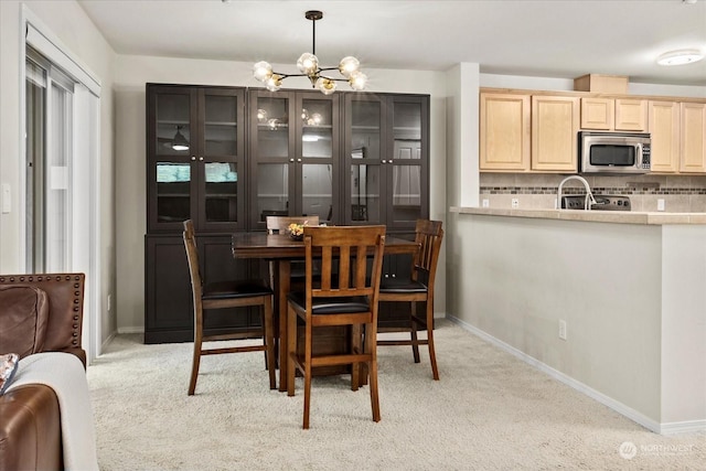 carpeted dining space with a chandelier