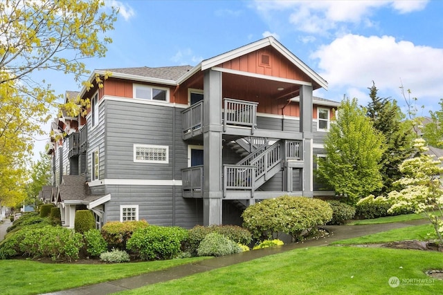 rear view of property featuring a lawn and a balcony