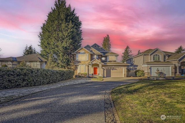 view of front of property with a garage and a lawn