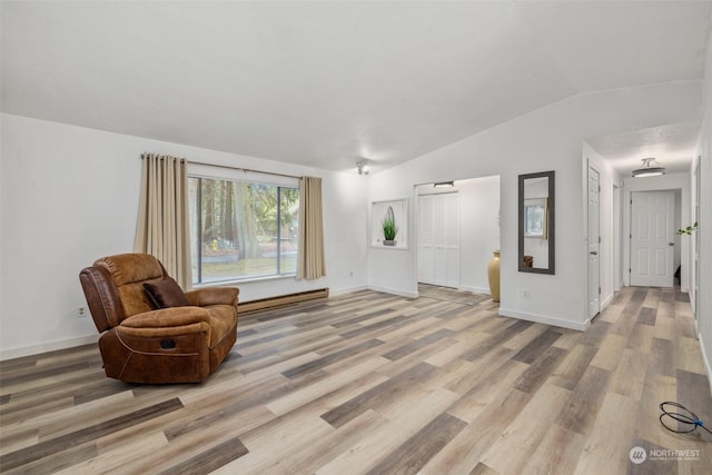 sitting room with vaulted ceiling, light hardwood / wood-style floors, and a baseboard radiator