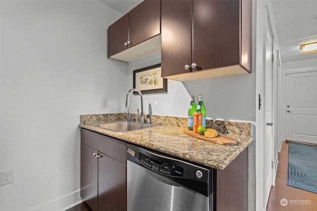 kitchen with dark brown cabinetry, light stone countertops, sink, stainless steel dishwasher, and wood-type flooring