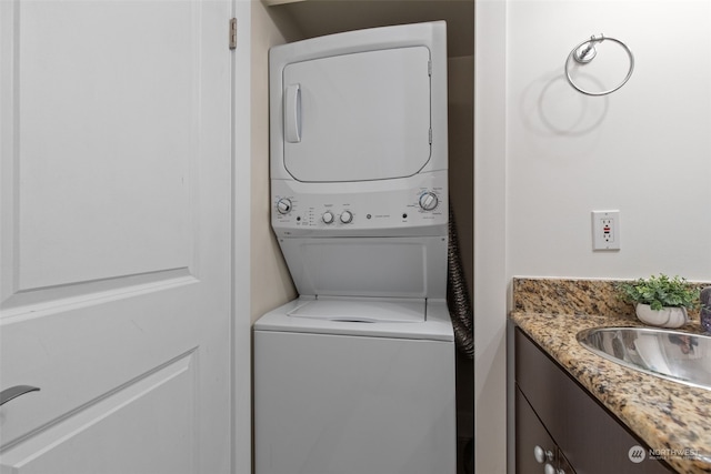 laundry room featuring stacked washer / dryer and sink