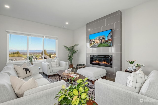 living room with hardwood / wood-style floors and a tiled fireplace