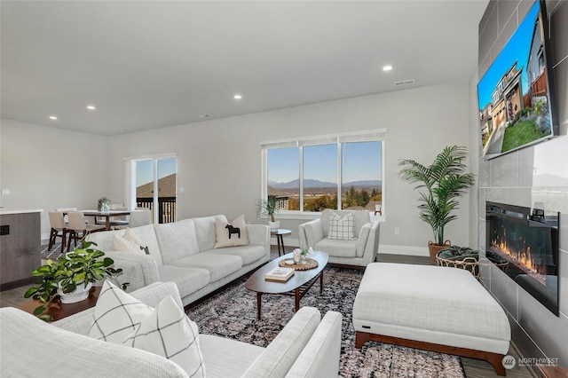 living room featuring hardwood / wood-style floors and a tiled fireplace