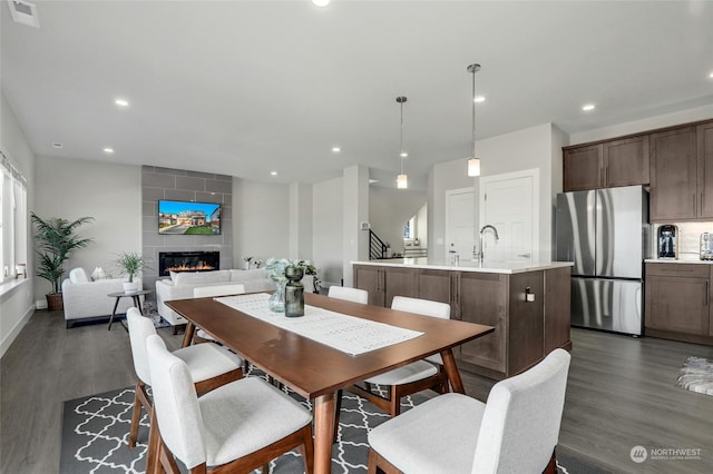 dining space with a fireplace, dark hardwood / wood-style floors, and sink