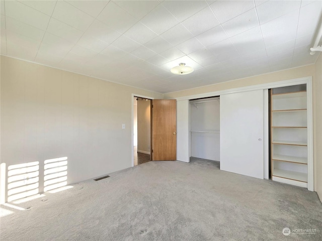 unfurnished bedroom featuring carpet flooring and a closet