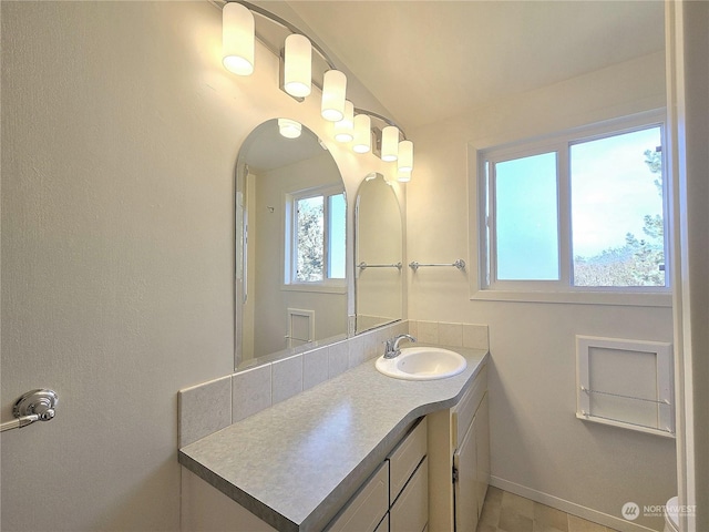 bathroom featuring lofted ceiling and vanity