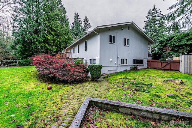 view of side of property featuring a yard and a wooden deck