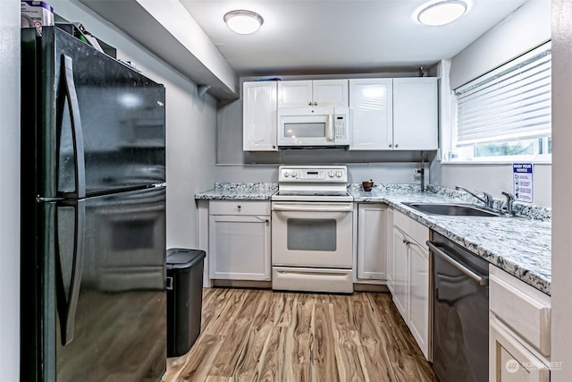 kitchen featuring light wood-type flooring, light stone counters, white appliances, sink, and white cabinetry