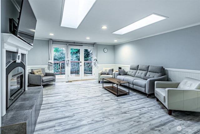 living room with french doors, ornamental molding, light hardwood / wood-style flooring, and a skylight