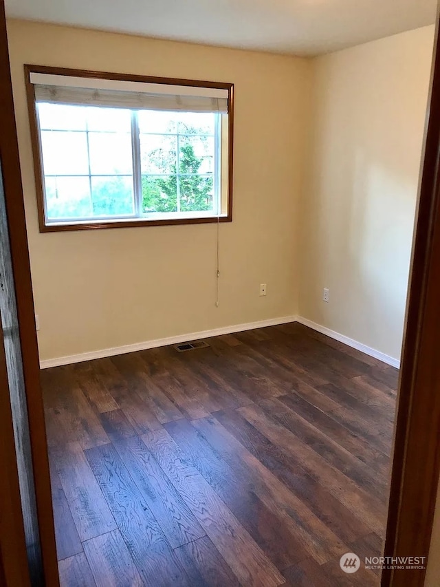 spare room featuring dark hardwood / wood-style flooring