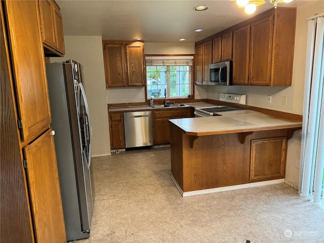 kitchen featuring stainless steel appliances, sink, a breakfast bar area, and kitchen peninsula