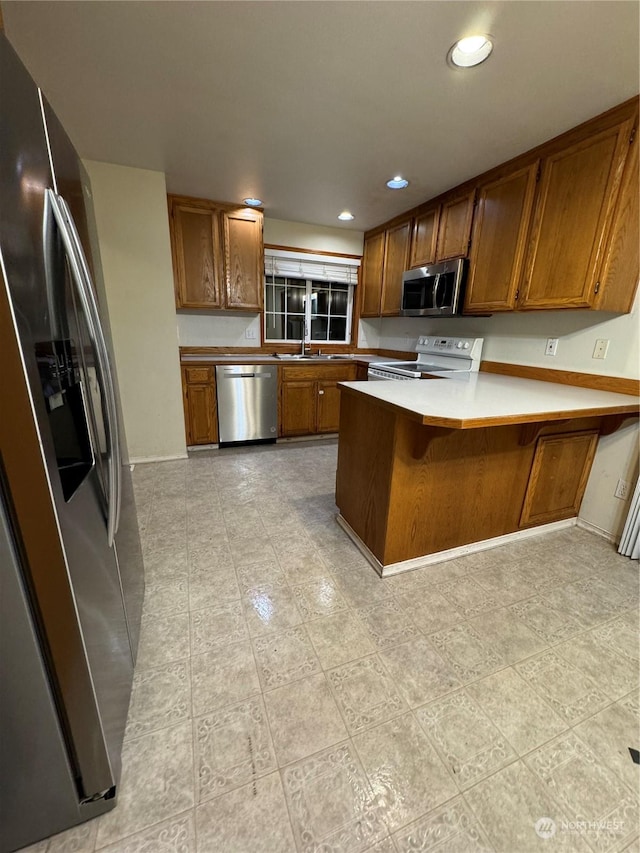 kitchen with a breakfast bar, stainless steel appliances, kitchen peninsula, and sink