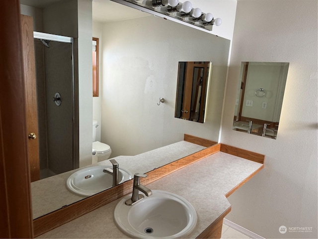 bathroom featuring vanity, walk in shower, and toilet
