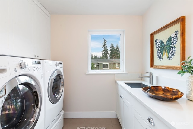 laundry area featuring cabinets, light tile patterned flooring, washer and clothes dryer, and sink