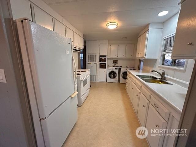 kitchen featuring white cabinets, washer and dryer, white appliances, and sink