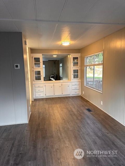 unfurnished living room with dark hardwood / wood-style flooring