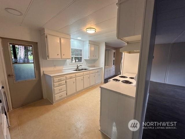 kitchen featuring white cabinets, white cooktop, a wealth of natural light, and sink