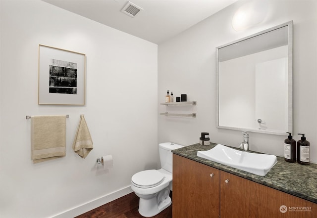 bathroom with hardwood / wood-style floors, vanity, and toilet