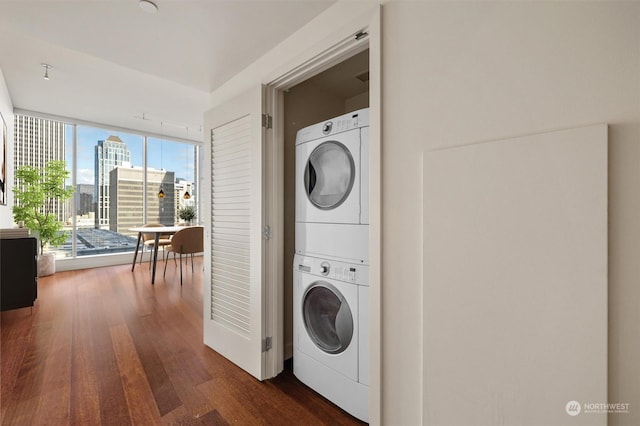 washroom featuring dark hardwood / wood-style flooring and stacked washer and dryer