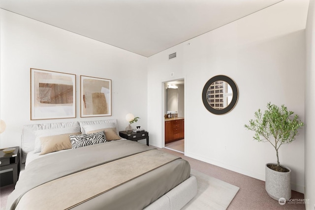 bedroom with ensuite bath and carpet floors