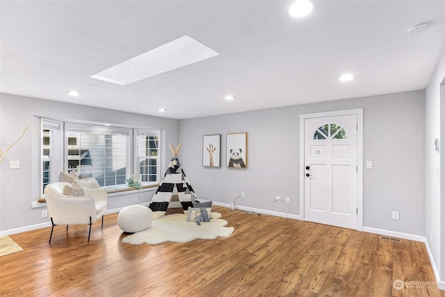 interior space with a skylight and wood-type flooring