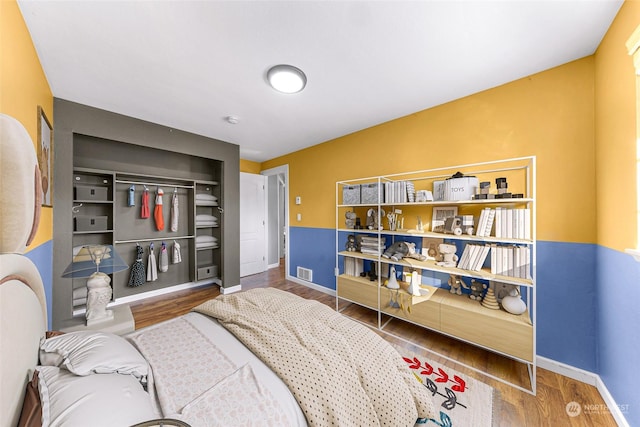 bedroom with hardwood / wood-style floors and a closet