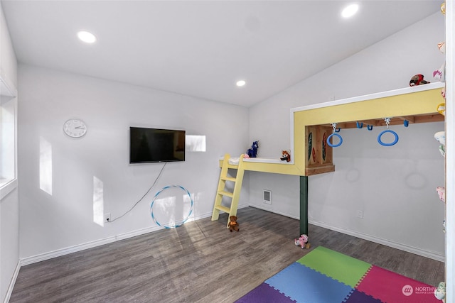 exercise room with dark wood-type flooring and lofted ceiling