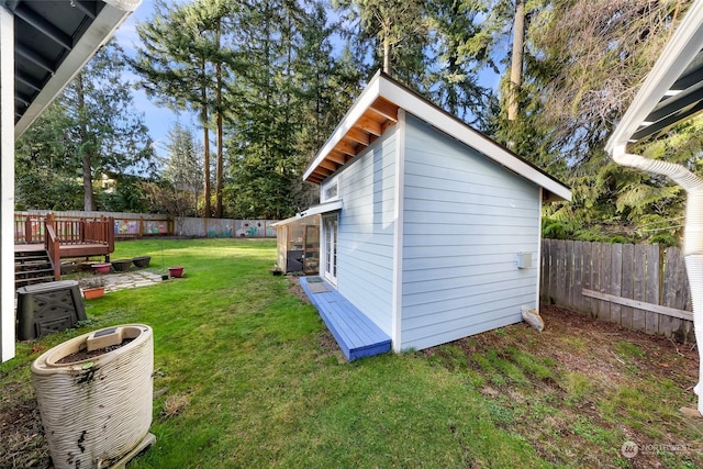 view of yard with a deck, cooling unit, and an outbuilding