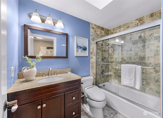 full bathroom featuring toilet, combined bath / shower with glass door, and vanity