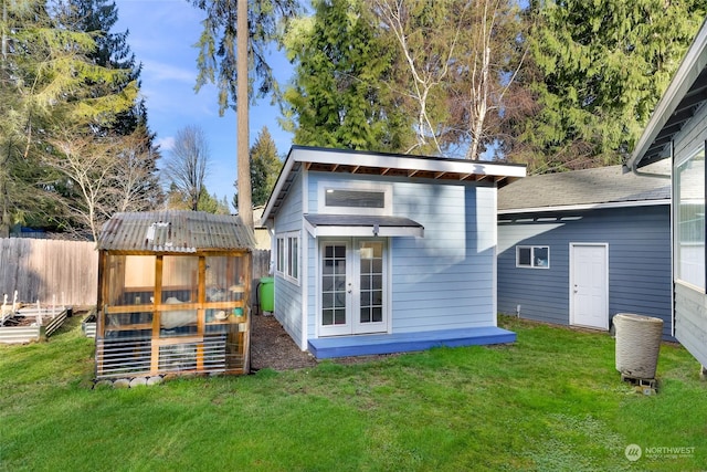 back of property featuring an outbuilding and a lawn